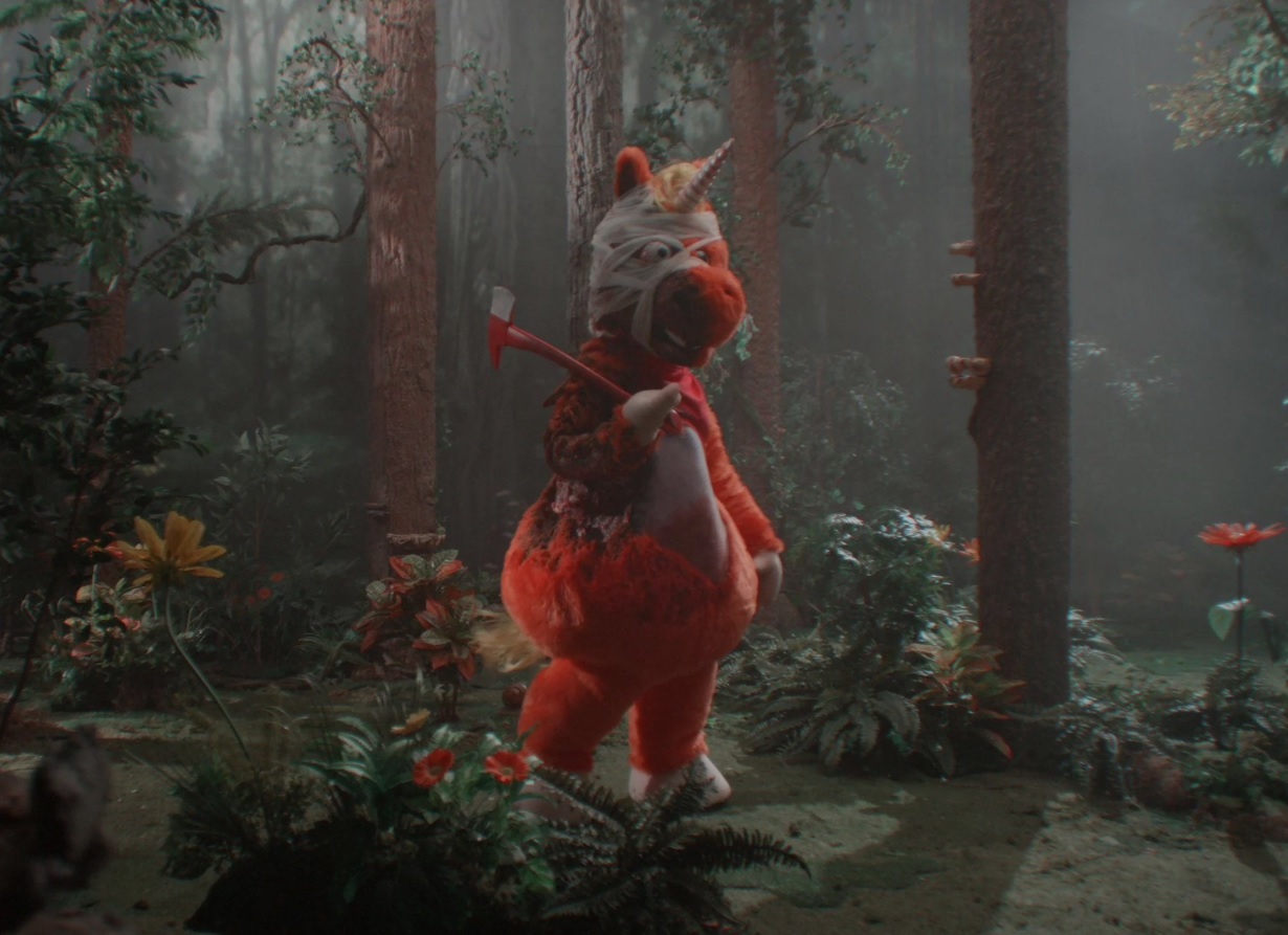 Bright orange unicorn Buddy from Casper Kelly’s 2026 horror comedy Buddy, which became a surprise indie box office hit with a $5.36 million opening weekend.
